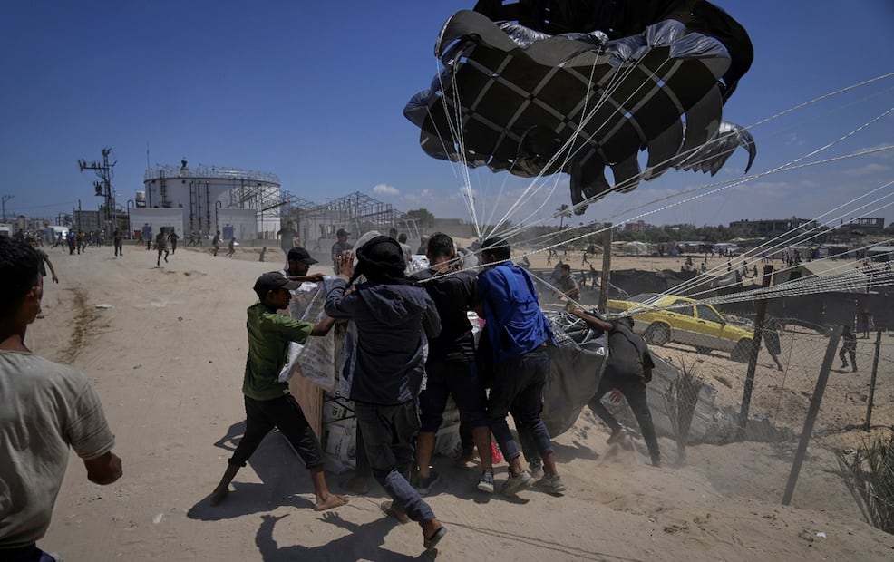 Palestinos se abalanzan sobre la ayuda humanitaria lanzada en paracaídas sobre Deir al-Balah, en el centro de la Franja de Gaza, el martes 5 de agosto de 2025. Foto: AP
