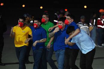 Migrantes venezolanos, presos en El Salvador, a su llegada anoche al Aeropuerto Internacional Simón Bolívar, en Venezuela. FOTO: FEDERICO PARRA. AFP