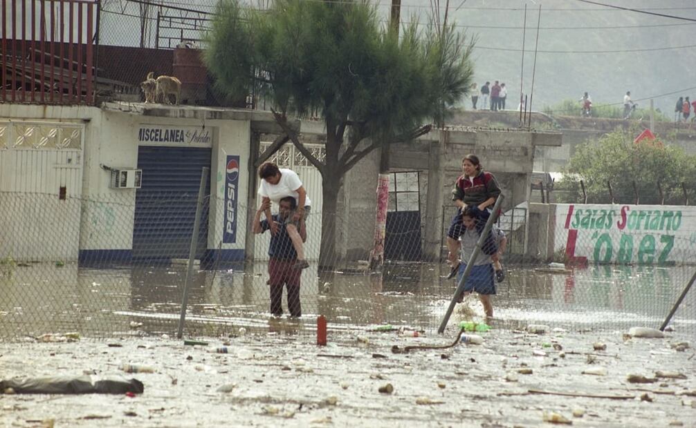 Ciudadanos de Chalco cargan a sus familiares para surcar las aguas negras, en la inundación del 2000. Foto: Jorge González/Archivo EL UNIVERSAL.