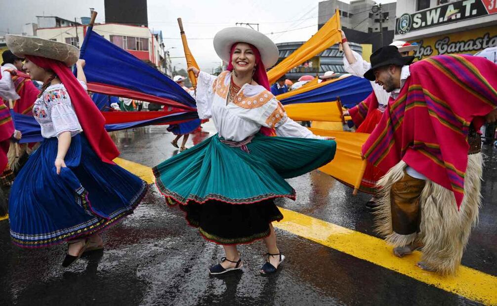 Un grupo de personas danza sin parar e interactúa con el público que ha desafiado la lluvia. Foto: AFP