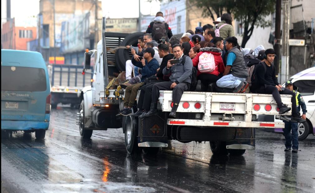 La gente trata de llegar a su destino caminando, sobre dovelas, en la plataforma de un camión de carga y hasta en la nariz de un camión de trasporte público concesionado, después de que la calzada Ignacio Zaragoza se encuentra inundada. Foto: Francisco Rodríguez/EL UNIVERSAL