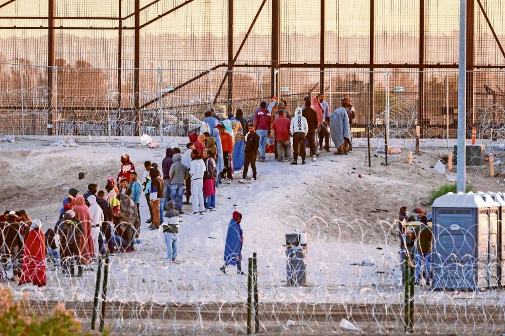 Migrantes esperan ser procesados y transportados ​​​​por oficiales de la Patrulla Fronteriza en la zona limítrofe entre EU y México, en El Paso, Texas, el 12 de mayo pasado.