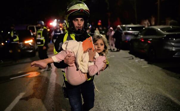 Un rescatista israelí con una menor, tras un ataque en Tel Aviv. Foto: Ohad Zwigenberg / AP