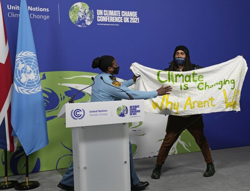 Manifestante se cuela a una de las presentaciones de la COP26 para demostrar inconformidad. Foto: AP/Alastair Grant