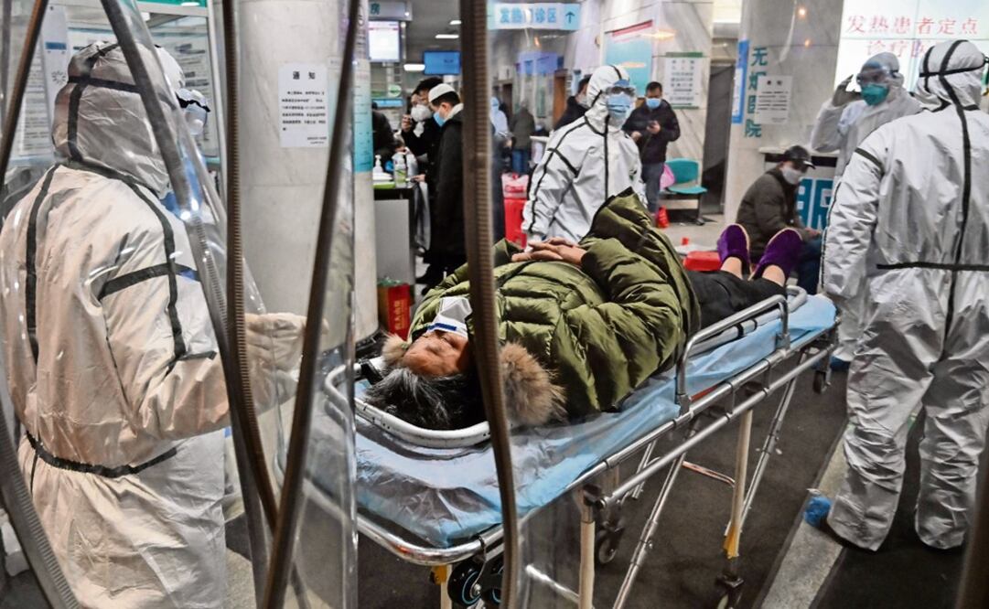 Medical staff members wearing protective clothing to help stop the spread of a deadly virus which began in the city, arrive with a patient at the Wuhan Red Cross Hospital in Wuhan on January 25, 2020 - Photo: Hector Retamal/AFP