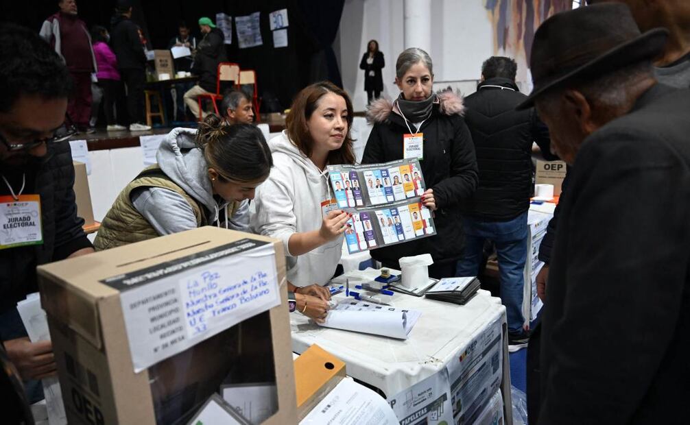 Un funcionario de mesa electoral muestra una papeleta a un votante durante las elecciones presidenciales en La Paz, el 17 de agosto de 2025. Los bolivianos acuden a las urnas el domingo para unas elecciones marcadas por una profunda crisis económica que ha visto a la izquierda colapsar y a la derecha aspirar a su primera oportunidad de poder en 20 años. Foto: AFP
