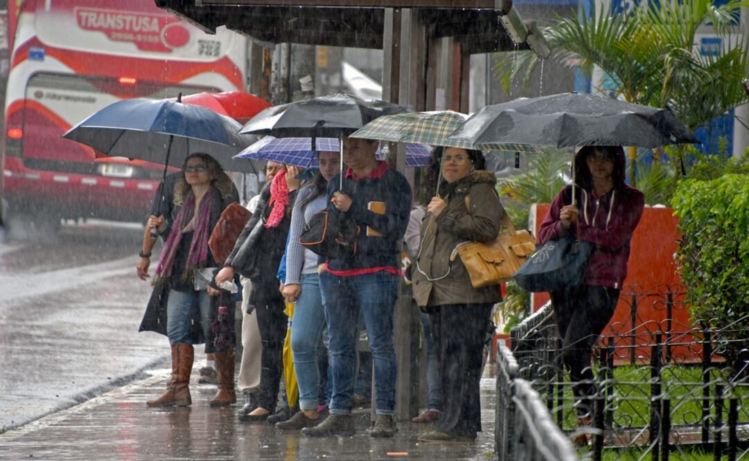 En la imagen, gente cubriéndose de la fuerte lluvia que provoca "Nate" a su paso por Costa Rica. Foto: AFP