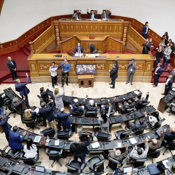 Diputados de la Asamblea Nacional de Venezuela, de mayoría opositora, votan durante la sesión de ayer en Caracas, en la que aprobaron una resolución que señala que Nicolás Maduro se apoderó ilegítimamente de la presidencia. MANAURE QUINTERO. REUTERS