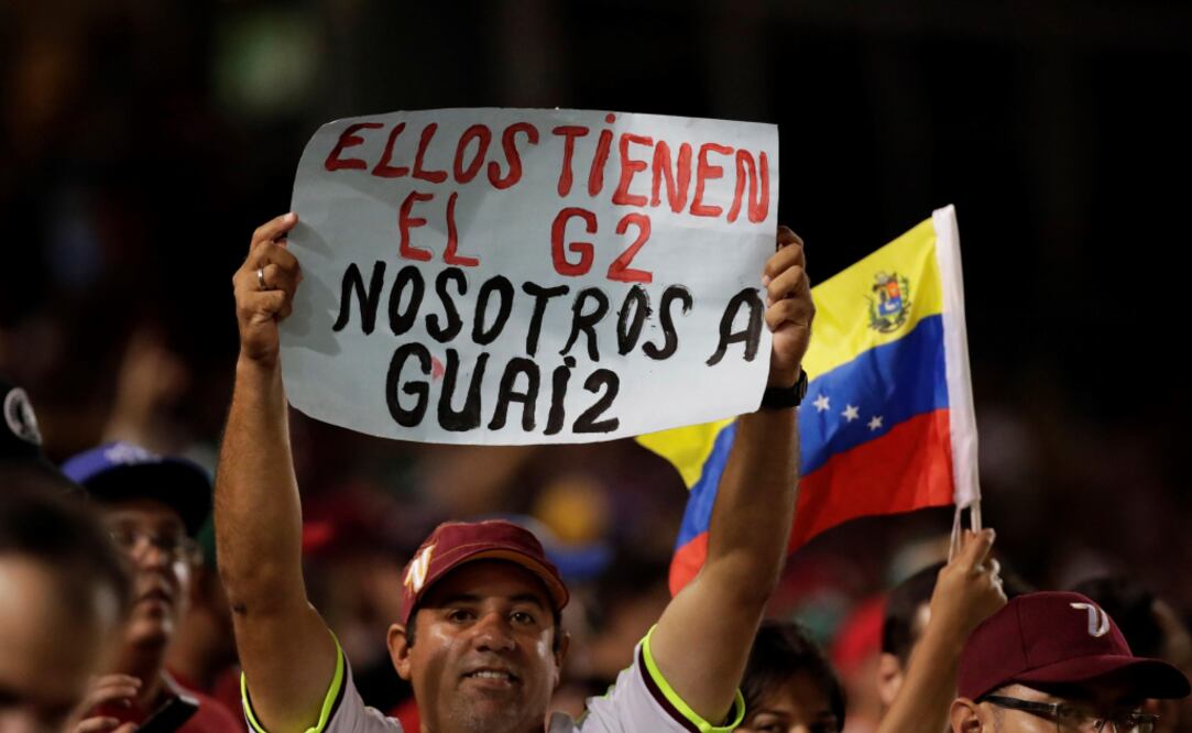 Un fanático del beisbol sostiene un mensaje en apoyo a Juan Guaidó. Foto: EFE