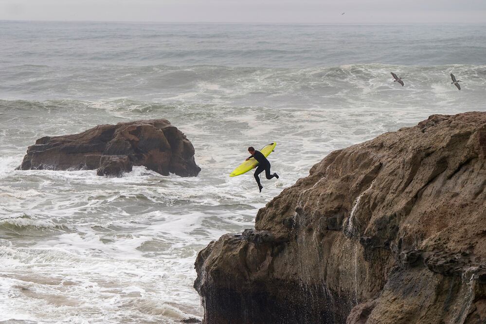 Un surfista salta desde un acantilado al agua en Steamer Lane en Santa Cruz, California. Foto: AP