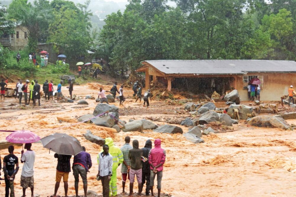 Un grupo de personas mira los destrozos dejados por las inundaciones en Freetown, capital de Sierra Leona. (SAIDU BAH. AFP)