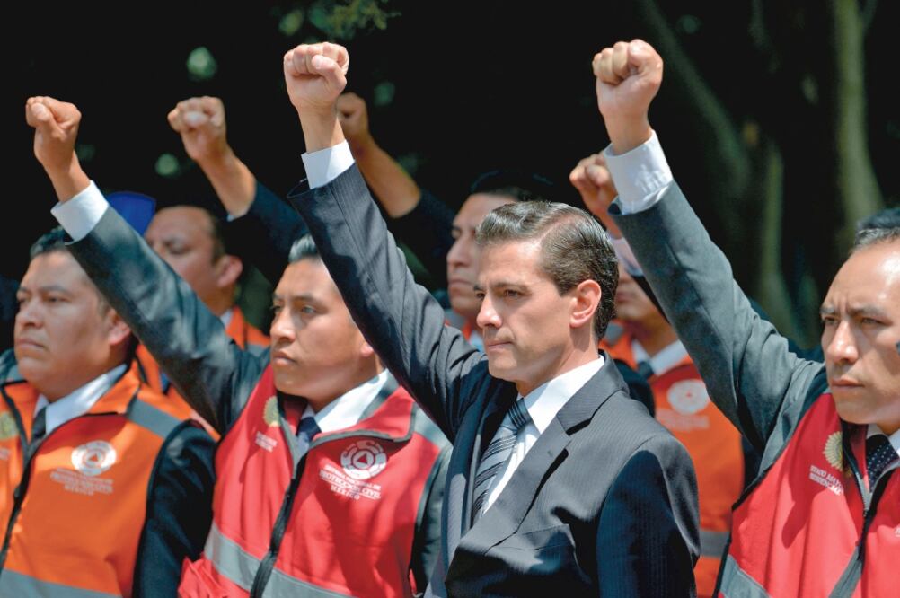 El presidente Enrique Peña Nieto, acompañado de brigadistas de Protección Civil, levantó el puño derecho para recordar a las personas que perdieron la vida en el sismo del 19 de septiembre de 2017. Foto: PRESIDENCIA