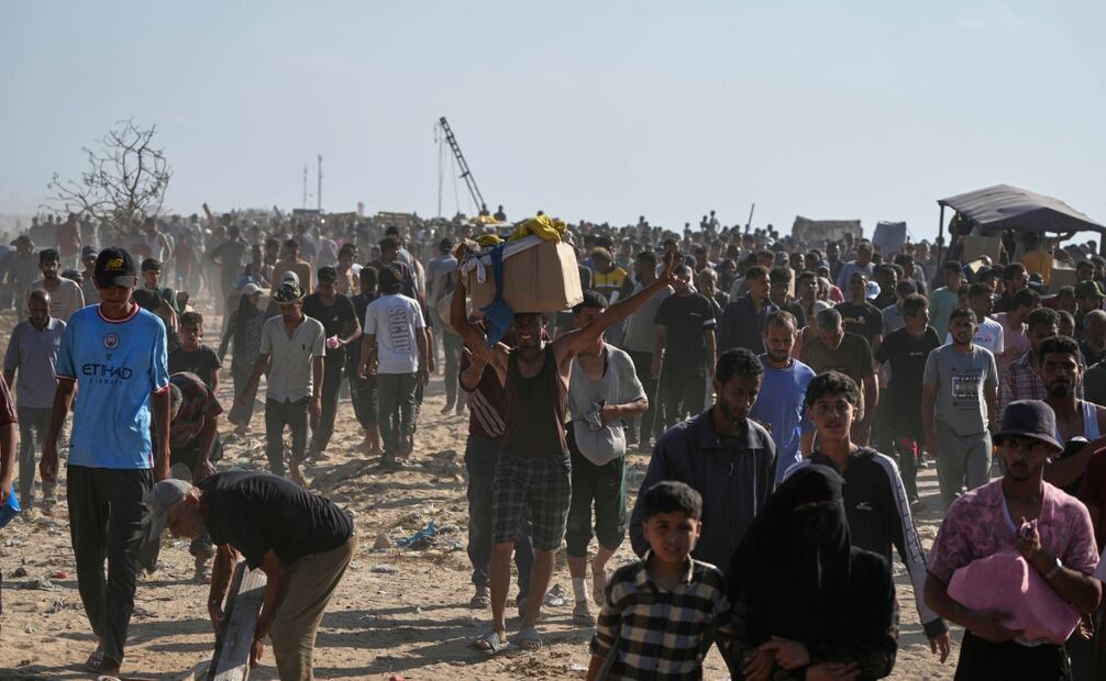 Palestinos llevan cajas con alimentos y paquetes de ayuda humanitaria entregados por la Fundación Humanitaria de Gaza, una organización respaldada por Estados Unidos y aprobada por Israel, en Rafah, en el sur de la Franja de Gaza, el martes 27 de mayo de 2025. Foto: AP