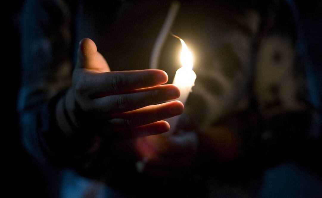 A woman holds a candle during a vigil in Sonora – Photo: File Photo/EL UNIVERSAL