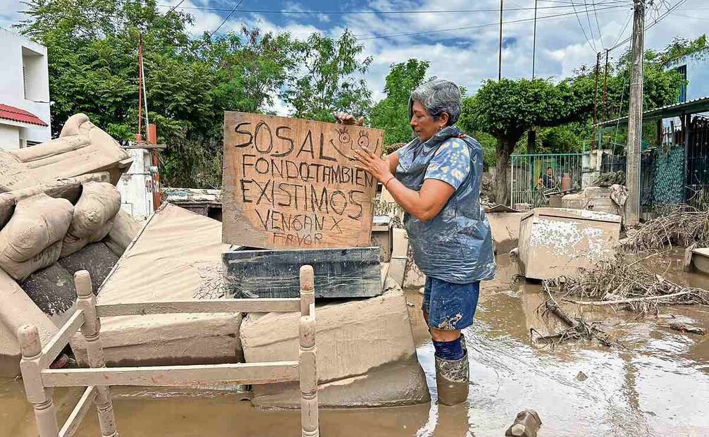 La señora Silvia Hernández coloca un cartel para pedir ayuda en la calle Garzas, en Poza Rica. Foto: Alhelí Salgado / EL UNIVERSAL