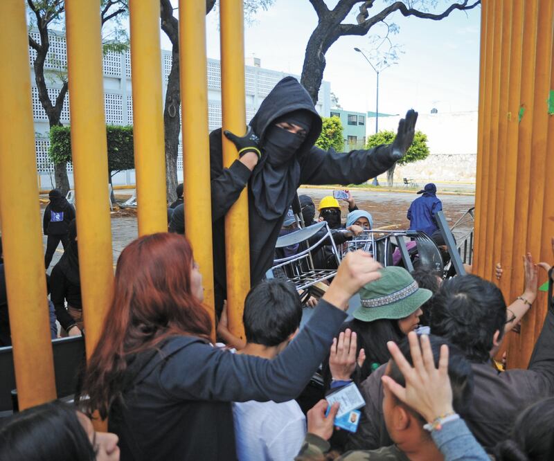 Alumnos y padres de familia de la Escuela Nacional Preparatoria 9 se enfrentaron con encapuchados que mantienen el paro en el plantel, luego de que intentaron recuperar las instalaciones para que sus hijos no pierdan el año. Foto: ESPECIAL