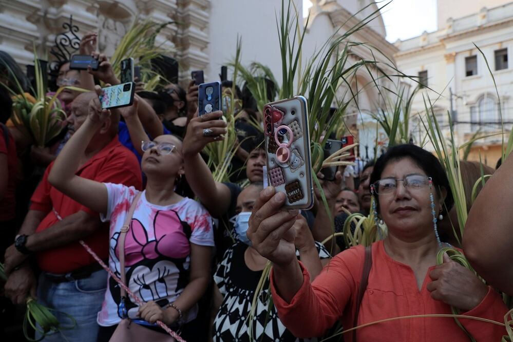Asistentes graban con sus teléfonos la celebración del Domingo de Ramos en la Catedral San Miguel Arcángel de Tegucigalpa, en Honduras. FOTO: GUSTAVO AMADOR. EFE