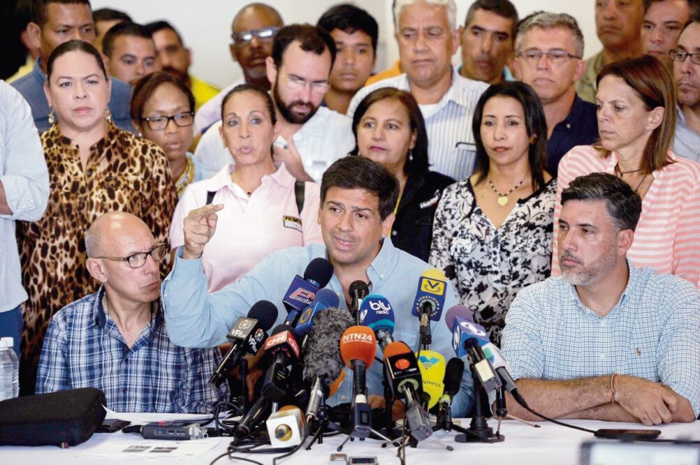 El candidato opositor para el estado de Miranda, Carlos Ocariz (centro), durante la conferencia de prensa en la que dijo que la MUD enfrentó “masificación del voto mú lt i ple” a favor del oficialismo, pero no presentó pruebas. (FEDERICO PARRA. AFP)