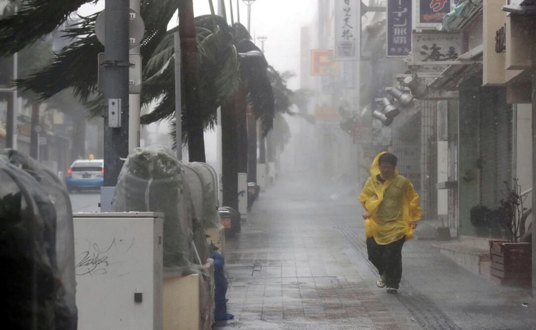 A passer-by walks in heavy rain and wind caused by Typhoon Trami in the prefectural capital Naha, on the southern island of Okinawa - Photo: Kyodo/via REUTERS