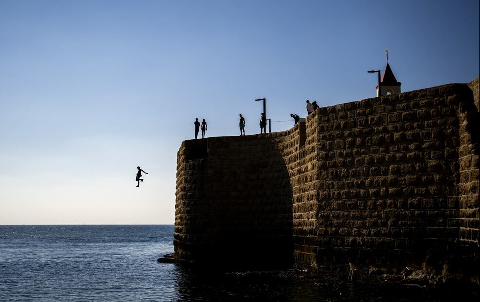 Jóvenes saltan al mar Mediterráneo en las antiguas murallas de la ciudad de Acre, Israel. Fotos: AP