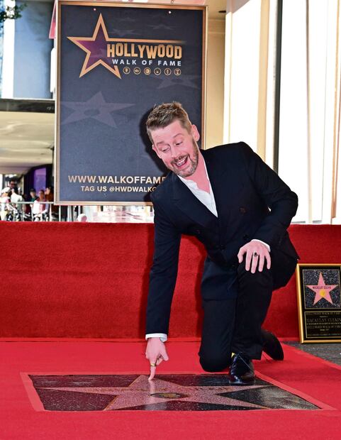 El actor estadounidense Macaulay Culkin señala su recién presentada estrella del Paseo de la Fama de Hollywood durante una ceremonia en Hollywood, California, el 1 de diciembre de 2023. Foto: Frederic J. BROWN / AFP. 