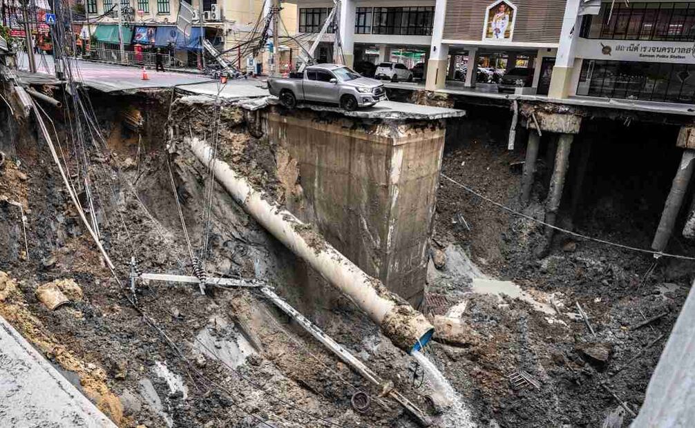 Se ve un vehículo al borde de un agujero en el suelo tras el derrumbe de una carretera cerca de un hospital en Bangkok el 24 de septiembre de 2025. Un tramo de una transitada carretera en la capital tailandesa se derrumbó la madrugada del 24 de septiembre, dejando un agujero de decenas de metros de profundidad frente a un hospital principal, lo que obligó a evacuar a los habitantes de las inmediaciones. Foto: AFP