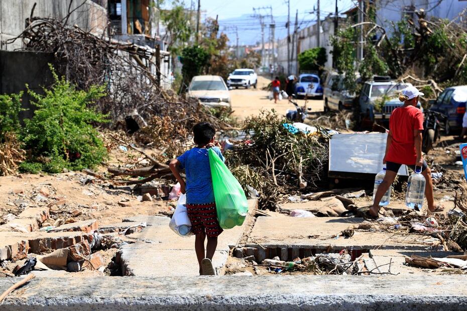 Damnificados caminan entre los escombros, en una de las zonas afectadas por el paso del huracán Otis, en el balneario de Acapulco, en el estado de Guerrero. FOTO: DAVID GUZMÁN. EFE