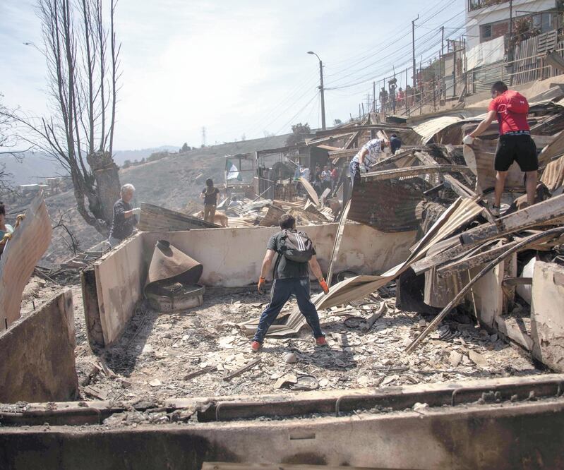 Residentes de Valparaíso buscan entre los escombros, tras los incendios que iniciaron el martes. Al menos 245 casas resultaron dañadas por el fuego. PABLO ROJAS MARADIAGA. AFP