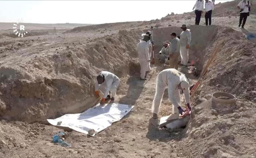 En esta imagen tomada de un video proporcionado por Rudaw TV, los trabajadores desentierran restos humanos en el sitio de Khasfa, cerca de la ciudad de Mosul, en el norte de Irak, donde las autoridades han comenzado a excavar una fosa común que se cree que contiene miles de víctimas del Estado Islámico, en Mosul, Irak, el domingo 17 de agosto de 2025. (17/08/25) Foto: AP