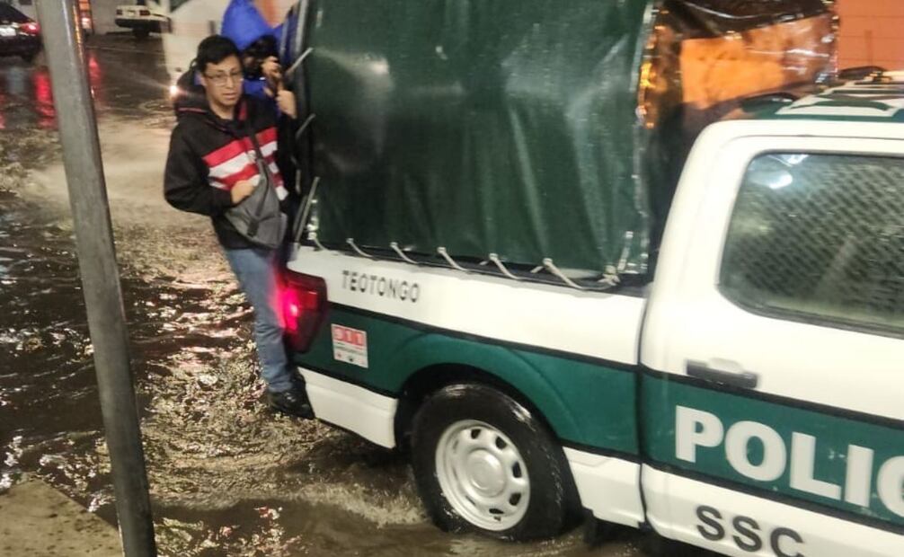 Policías ayudan en el traslado de personas por inundaciones. Foto: Especial.