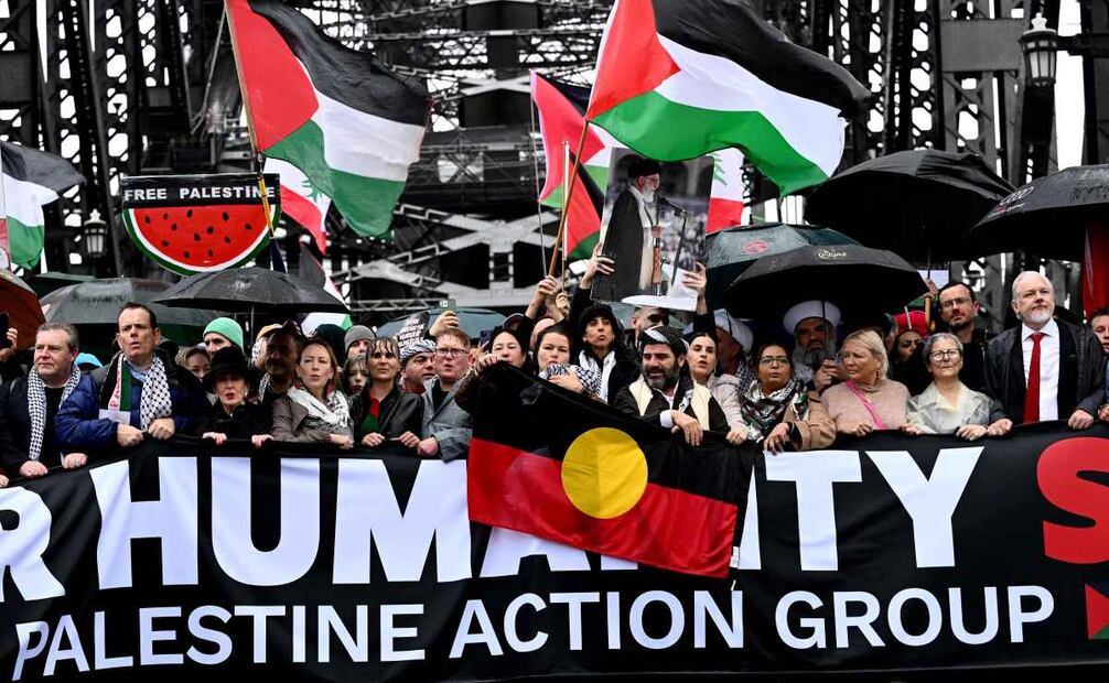 Manifestantes, entre ellos el fundador de WikiLeaks, Julian Assange (derecha), cruzan el puente del puerto de Sídney durante una manifestación pro palestina contra las acciones de Israel y la escasez de alimentos en la Franja de Gaza, en Sídney, el 3 de agosto de 2025. Foto: AFP