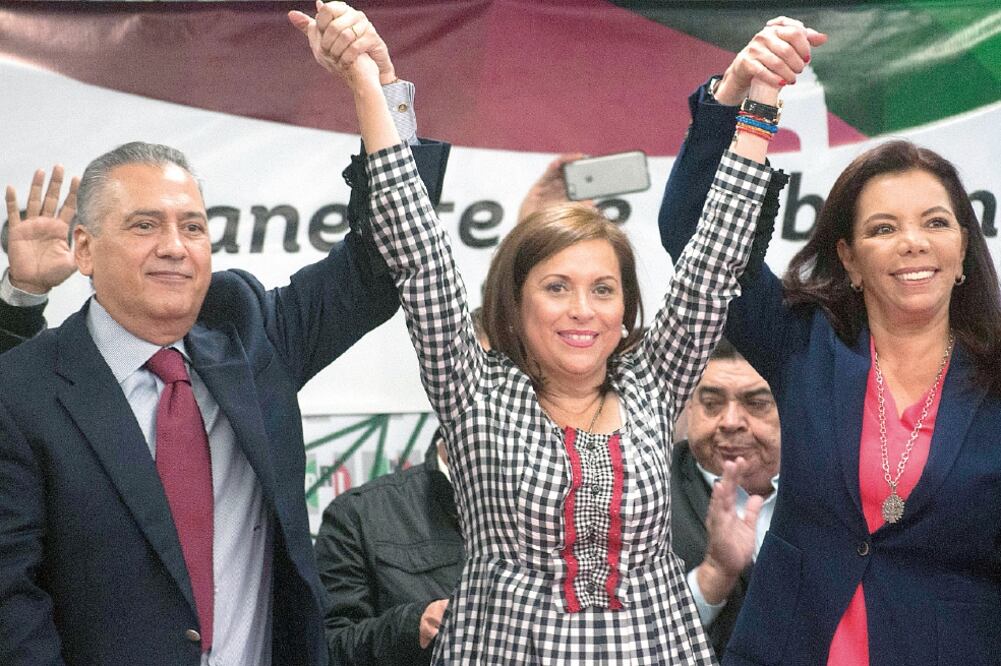 Cristina Díaz, líder de la CNOP, en medio de Manlio Fabio Beltrones y Carolina Monroy levanta los brazos de ambos en muestra de triunfo (DIEGO SÁNCHEZ. CUARTOSCURO)