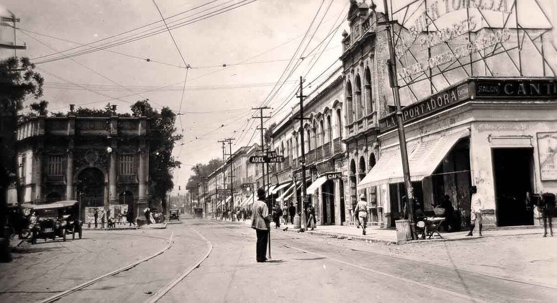 Un hombre dirige el tránsito en el actual cruce de Revolución y Jalisco, en Tacubaya, en el año 1928. Del lado izquierdo destaca la residencia de la familia Mier, de la cual aún existe la Fundación Mier y Pesado, así como varios edificios en la zona de su propiedad. Esta construcción se inspiró en el Arco de Constantino, en Roma, pero fue demolida poco después de esta toma, para erigir en su lugar el Edificio Ermita que aún sigue en pie y es característico de esta colonia. Foto: Colección Eduardo Zárate/ Especial.