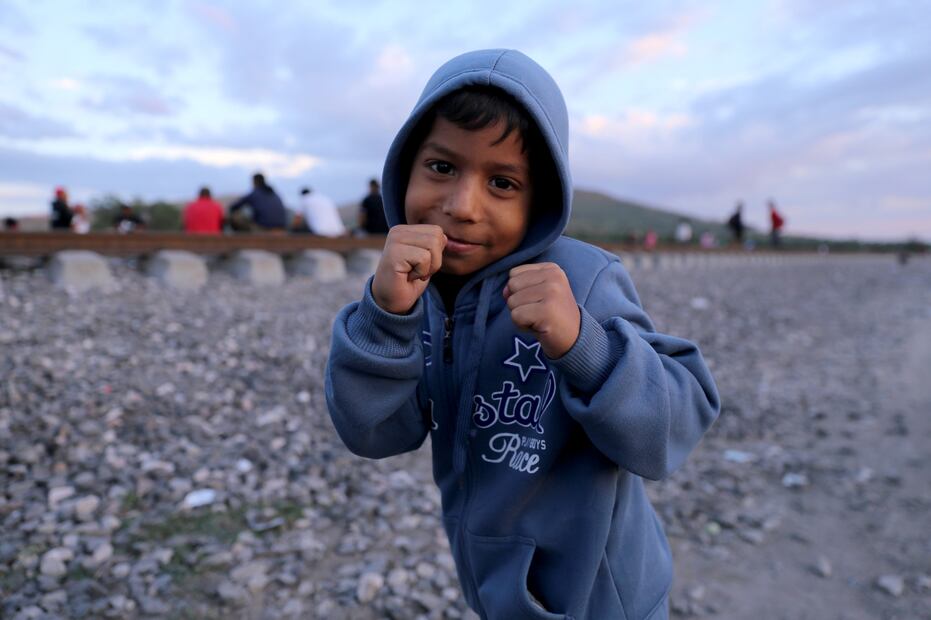 Pequeño boxeador migrante posa mientras espera el tren con su familia FOTO Diego Prado