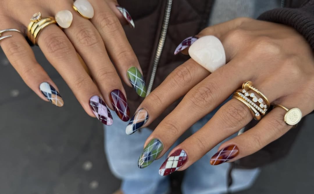 Manicura estilo suéter "argyle" con una mezcla de tonos cálidos y fríos, perfecta para sumar textura visual y un aire invernal al look. Foto: Instagram @chummy.nails