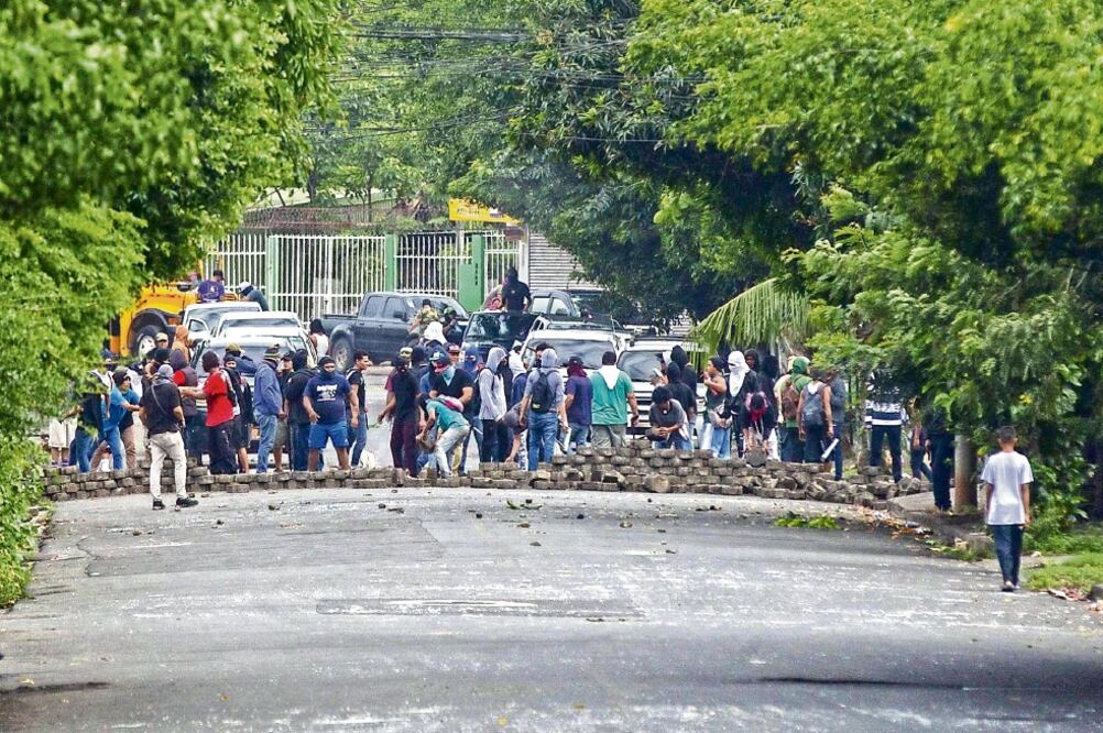 Manifestantes desmontan una barricada en un barrio de la capital de Nicaragua. Ayer, grupos paramilitares arrasaron con varias barricadas que opositores habían levantado en cuatro populosos barrios de la zona oriental de la capital. Foto: JORGE TORRES.EFE