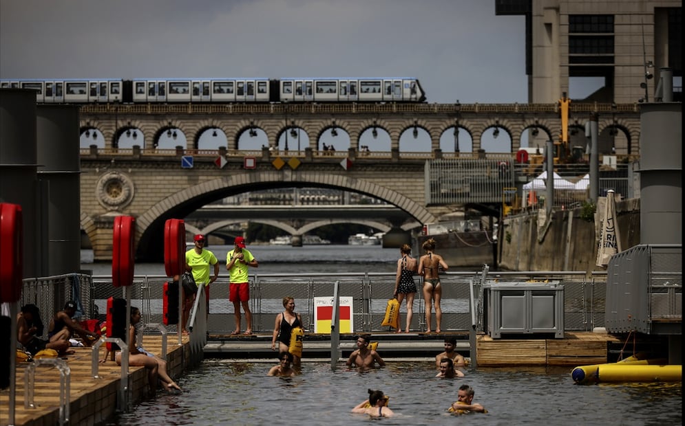 Bañistas en la zona de Bercy en el Sena. El acceso a estas zonas es gratuito y se regirá dentro de los horarios establecidos hasta el 31 de agosto. Foto: AP