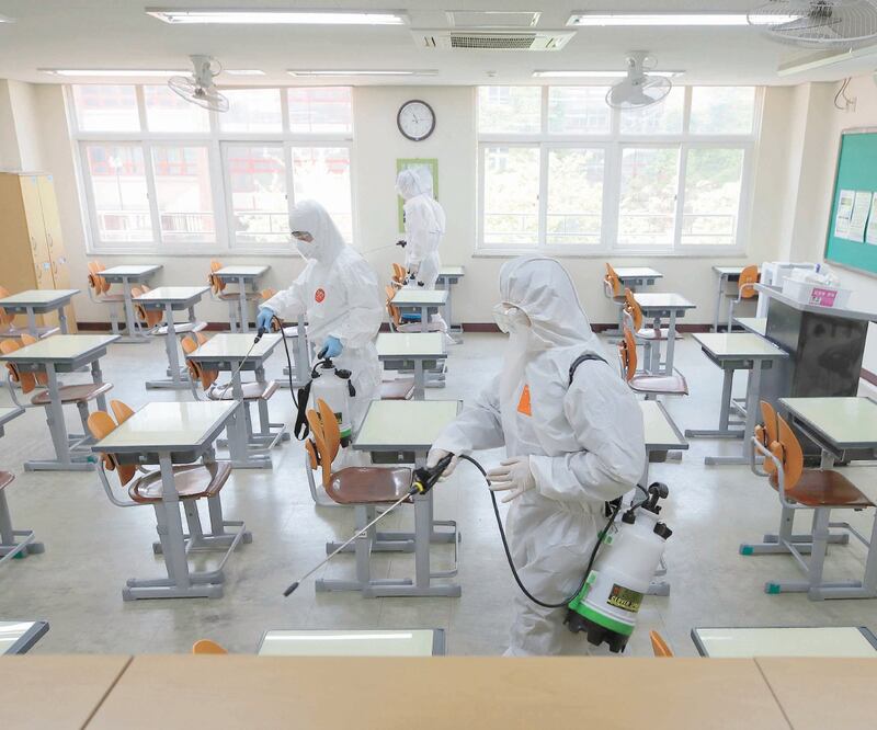 Personal de salud en Corea del Sur desinfecta una escuela secundaria en Seúl. El país vive un rebrote y se suspendió el regreso a clases. LEE JIN-MAN. AP