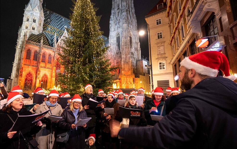 Miembros de un coro actúan durante el encendido oficial de las luces navideñas en el centro de la ciudad de Viena, Austria. Este año la capital austriaca ha decidido gastar más para garantizar que las luces brillen aún más en sus mercados icónicos. Foto: AFP