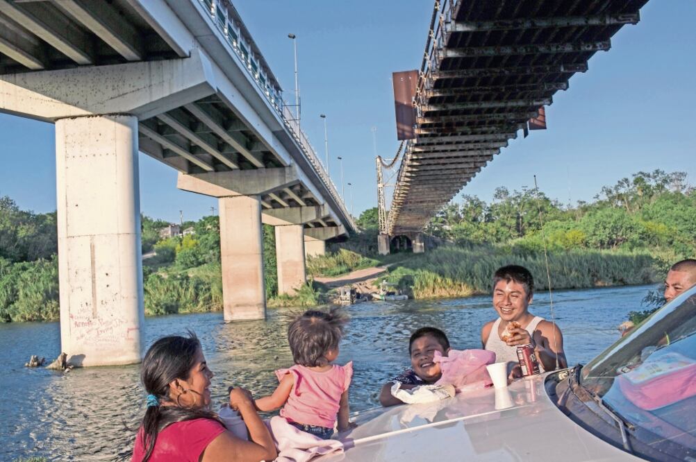 Una familia realiza un picnic a la orilla del Río Bravo en Miguel Alemán, Tamaulipas. En el gobierno de W. Bush, México tuvo que intervenir varias veces para impedir que el muro cruzara sobre el río. (AP)