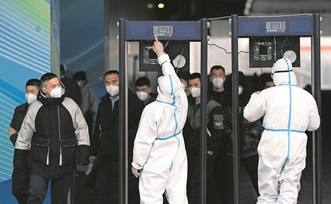 Integrantes del personal de seguridad, con detectores de metales en el principal centro de medios para los Juegos Olímpicos de Invierno, en Beijing. Foto: Jae C. Hong. AP