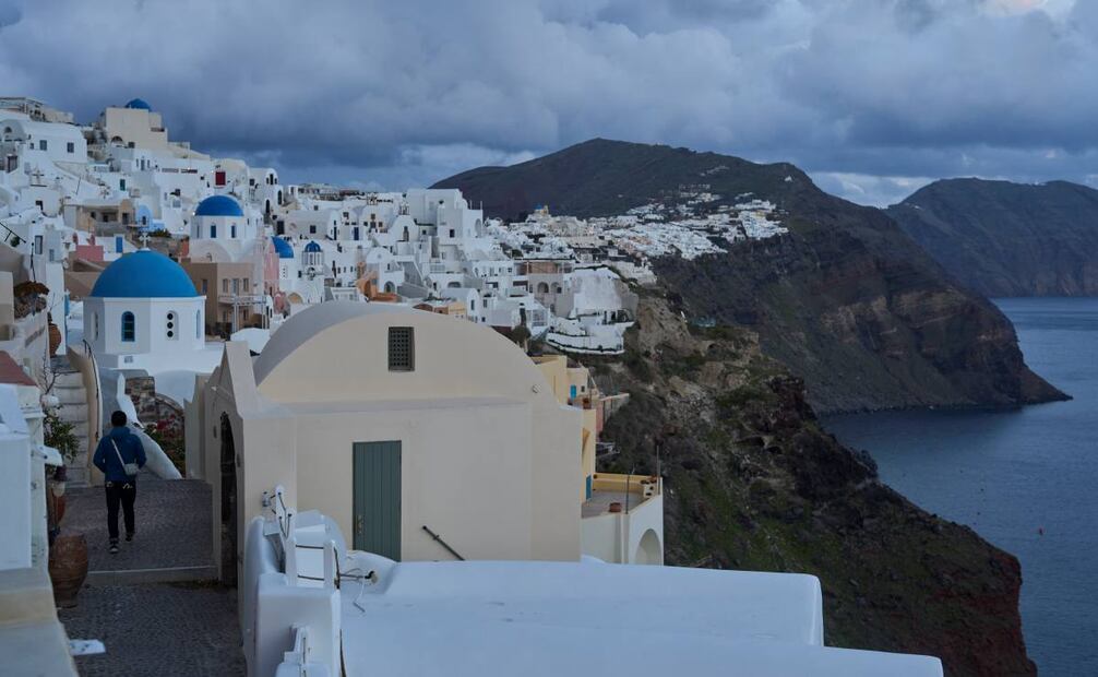 Un turista se acerca a las iglesias ortodoxas con cúpulas azules en la ciudad de Oia, en la isla de Santorini, Grecia, afectada por un terremoto, el martes 4 de febrero de 2025. Foto: AP