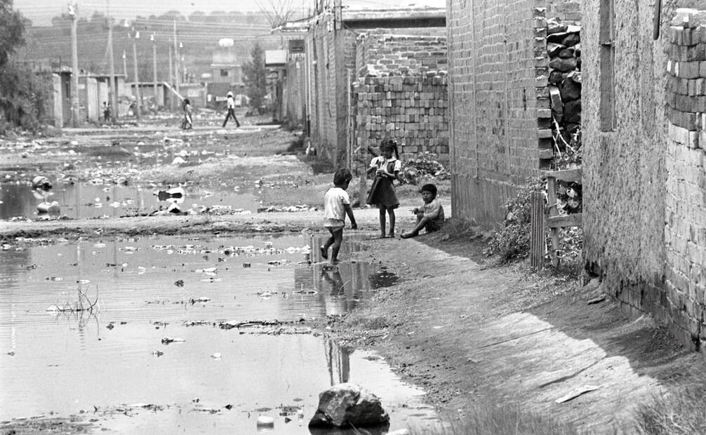 Niños juegan en calles llenas de agua estancada en Chalco, 1991. “El principal problema es la carencia de drenaje, lo que ocasiona en temporada de lluvias que las calles se inunden”, mencionó este diario. Foto: Jorge Ríos/Archivo EL UNIVERSAL.