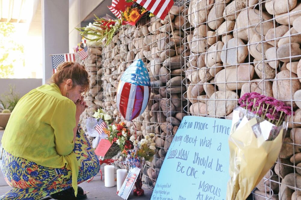 Una mujer presenta sus respetos a la memoria del senador John McCain, ante el altar improvisado en sus oficinas de Phoenix, Arizona (CONOR RALPH. REUTERS)