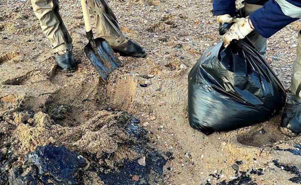 Una imagen publicada por el servicio de prensa del Ministerio de Situaciones de Emergencia de Rusia muestra a empleados del Ministerio de Situaciones de Emergencia de Rusia recogiendo arena de playa empapada de petróleo durante una operación de limpieza de derrames de petróleo en el estrecho de Kerch, Rusia, el 18 de diciembre de 2024. Según el departamento del Ministerio de Emergencias de Rusia en Crimea, el 15 de diciembre los petroleros Volgoneft-212 y Volgoneft-239 chocaron durante una tormenta, provocando un derrame de petróleo en el Mar Negro. Foto: EFE