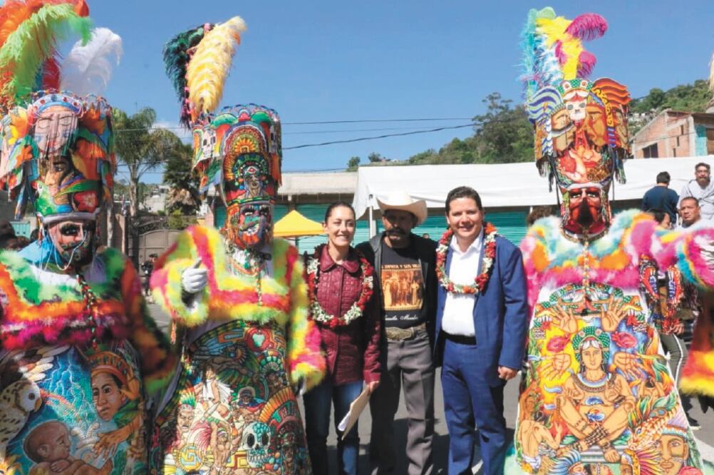 Claudia Sheinbaum (izq.), jefa de Gobierno, y Octavio Rivero Villaseñor (der), edil de Milpa Alta, posan junto a los chinelos que acudieron a la entrega de 30 nuevas patrullas de la policía, en la explanada de la alcaldía. Foto/ESPECIAL
