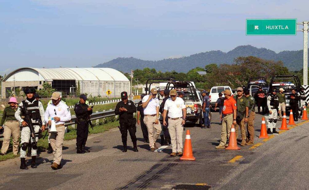 Personal del Instituto Nacional de Migración (INM) y de la Guardia Nacional (GN) bloquean una carretera ante el avance de una caravana de migrantes que caminan hacia la frontera con Estados Unidos este jueves, en el municipio de Huiixtla, en el estado de Chiapas (México). Integrantes de la caravana migrante en el estado de Chiapas, al sur de México, denunciaron este jueves que las autoridades les bloquearon la entrada al municipio de Huixtla, donde pretendían descansar, por lo que urgieron al gobierno de la presidenta Claudia Sheinbaum intervenir para que no se violen sus derechos humanos. Foto: EFE