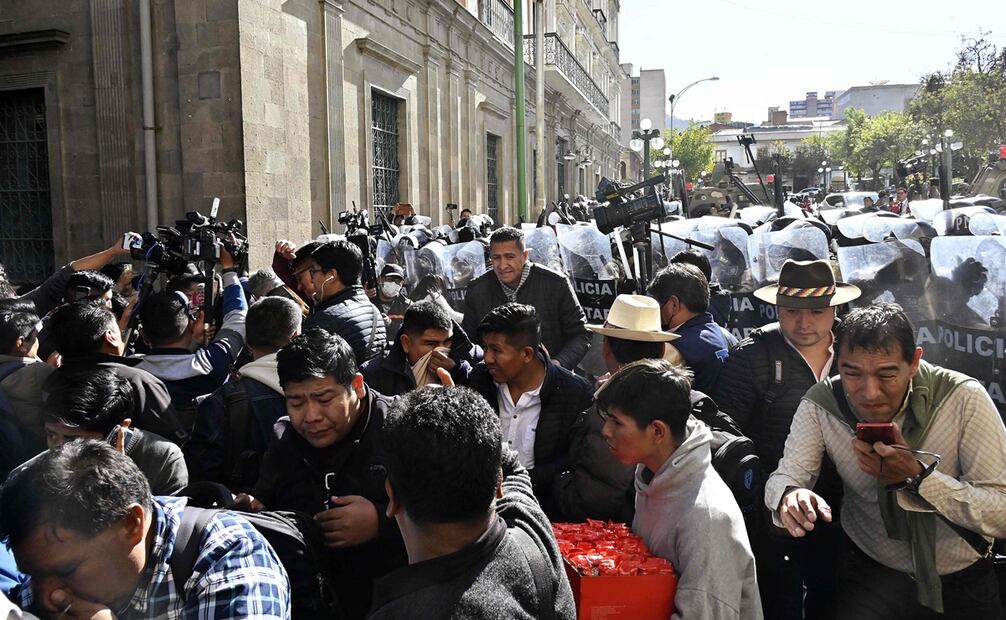 La gente se aleja de los gases lacrimógenos disparados por militares frente al Palacio Quemado en la Plaza de Armas de La Paz. Foto: AIZAR RALDES / AFP