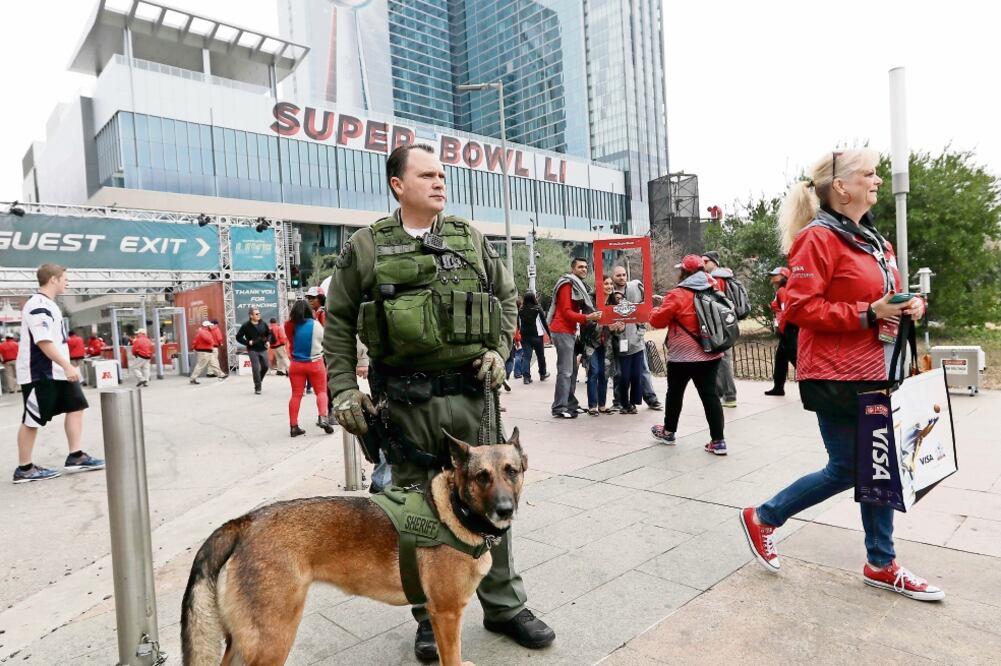 Los perros entrenados para detectar explosivos se pasean entre los miles de aficionados. (DAVID J. PHILLIP. AP)