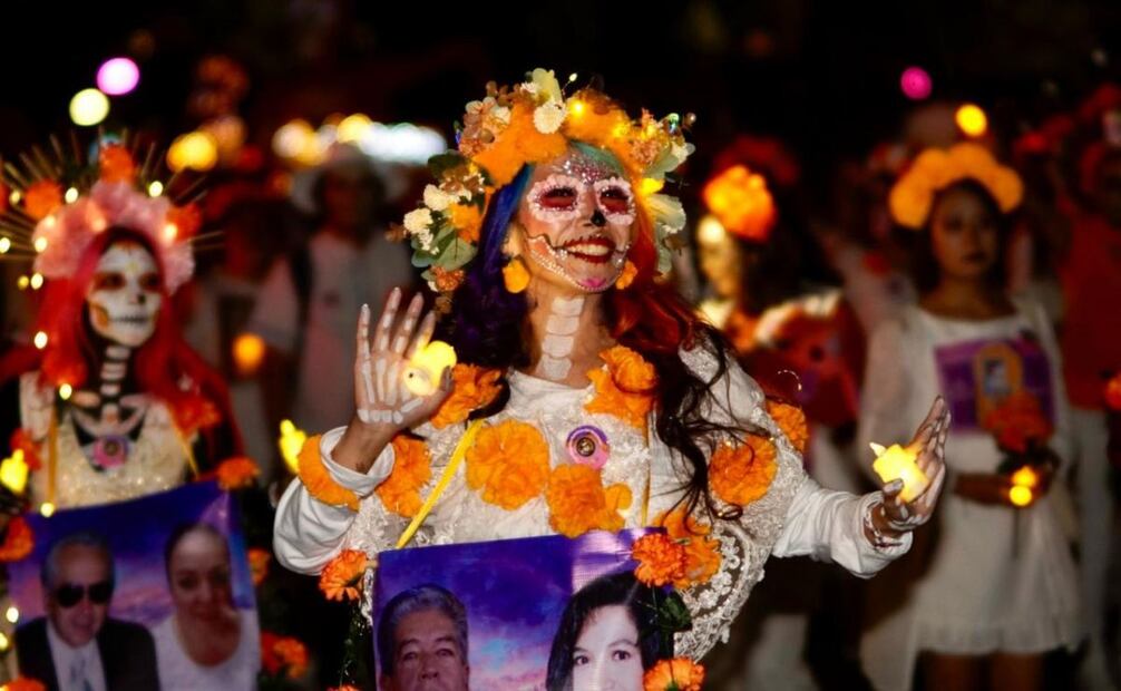 Personas con fotos de familiares fallecidos desfilan en la Mega Procesión de Catrinas en la CDMX 2025 (26/10/2025). Foto: Hugo Salvador / EL UNIVERSAL